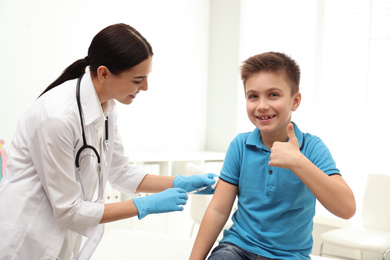 Photo of Doctor vaccinating little child in modern clinic