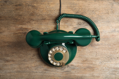 Photo of Vintage corded phone on wooden table, top view