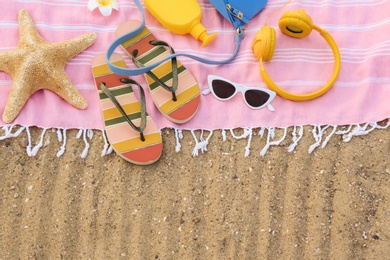 Composition with beach accessories on sand, flat lay. Space for text