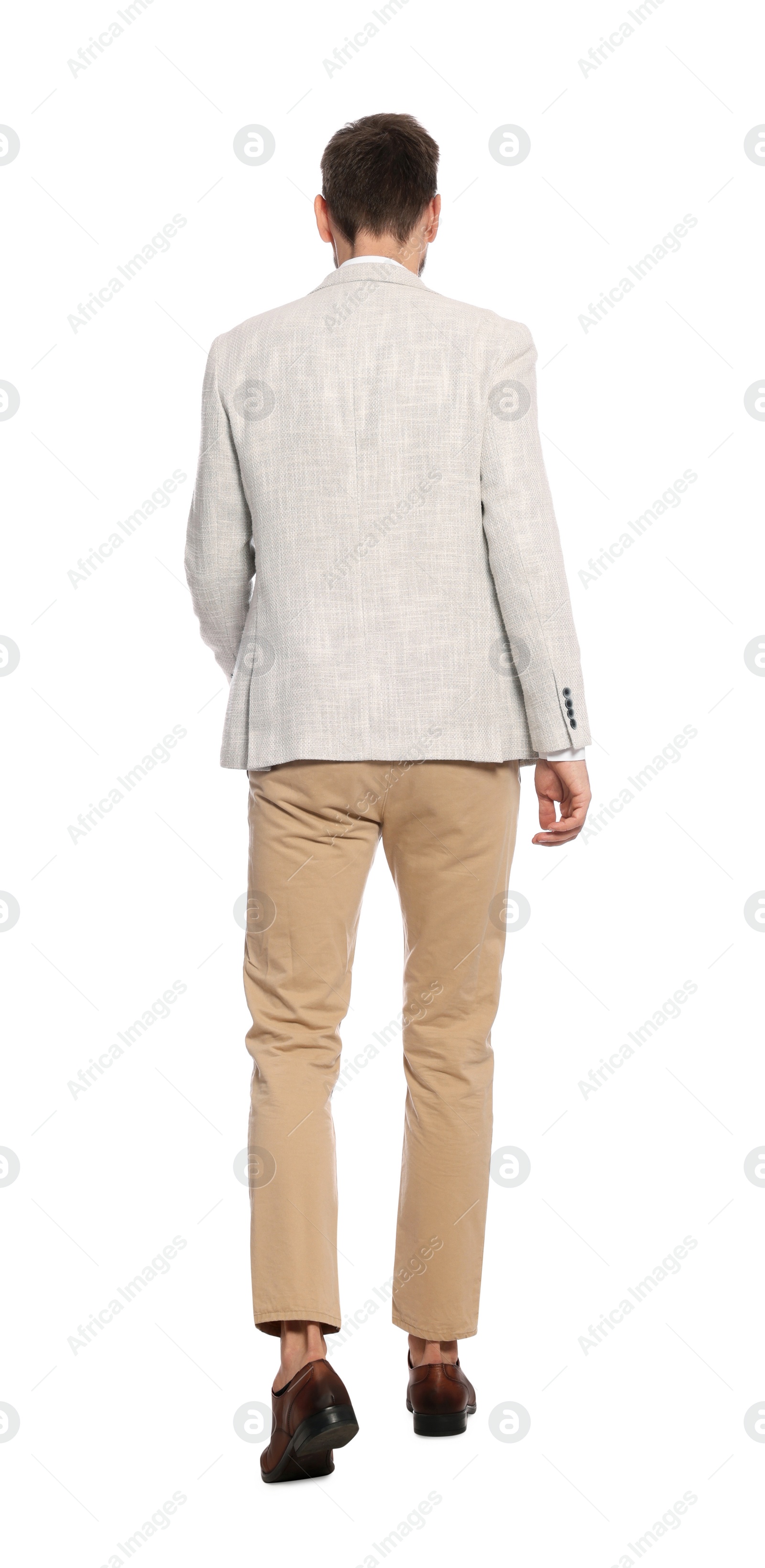 Photo of Man in stylish outfit walking on white background, back view