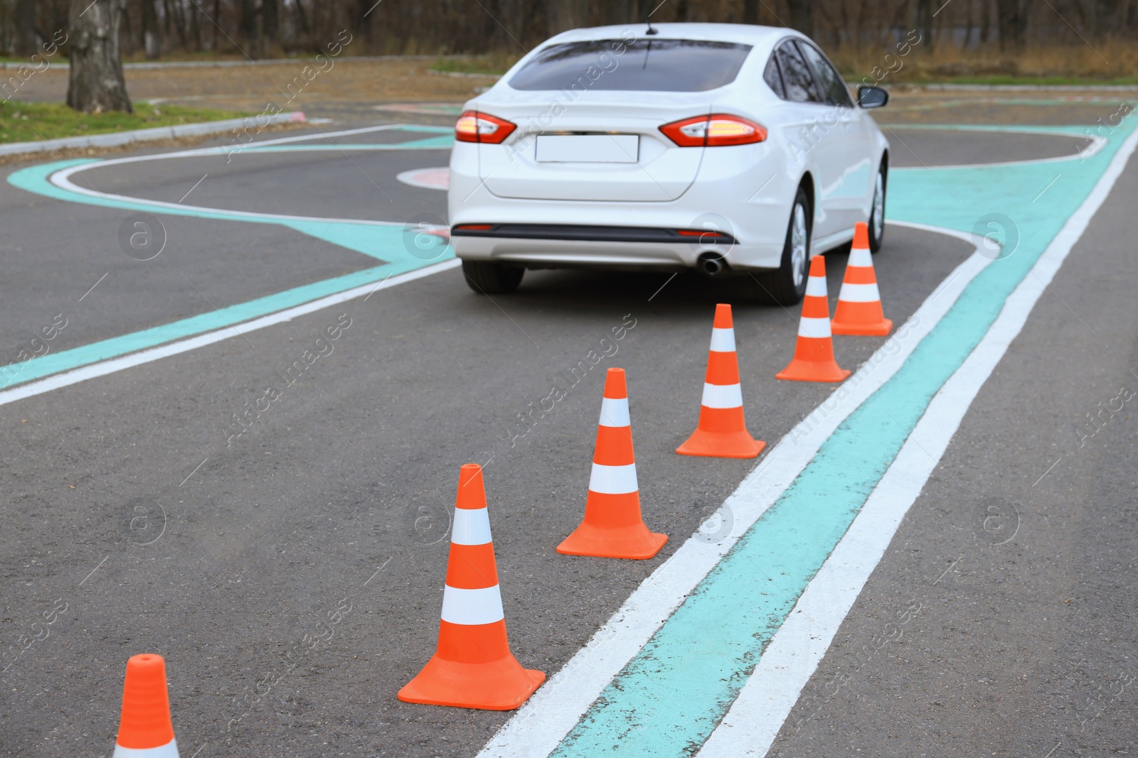 Photo of Modern car on driving school test track with traffic cones