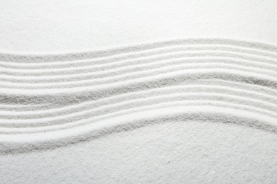 Photo of Zen rock garden. Wave pattern on white sand