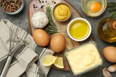 Photo of Delicious homemade mayonnaise, spices and ingredients on grey table, flat lay