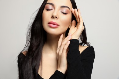 Portrait of beautiful young woman on light grey background