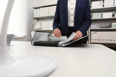 Woman working with documents at table in office, closeup