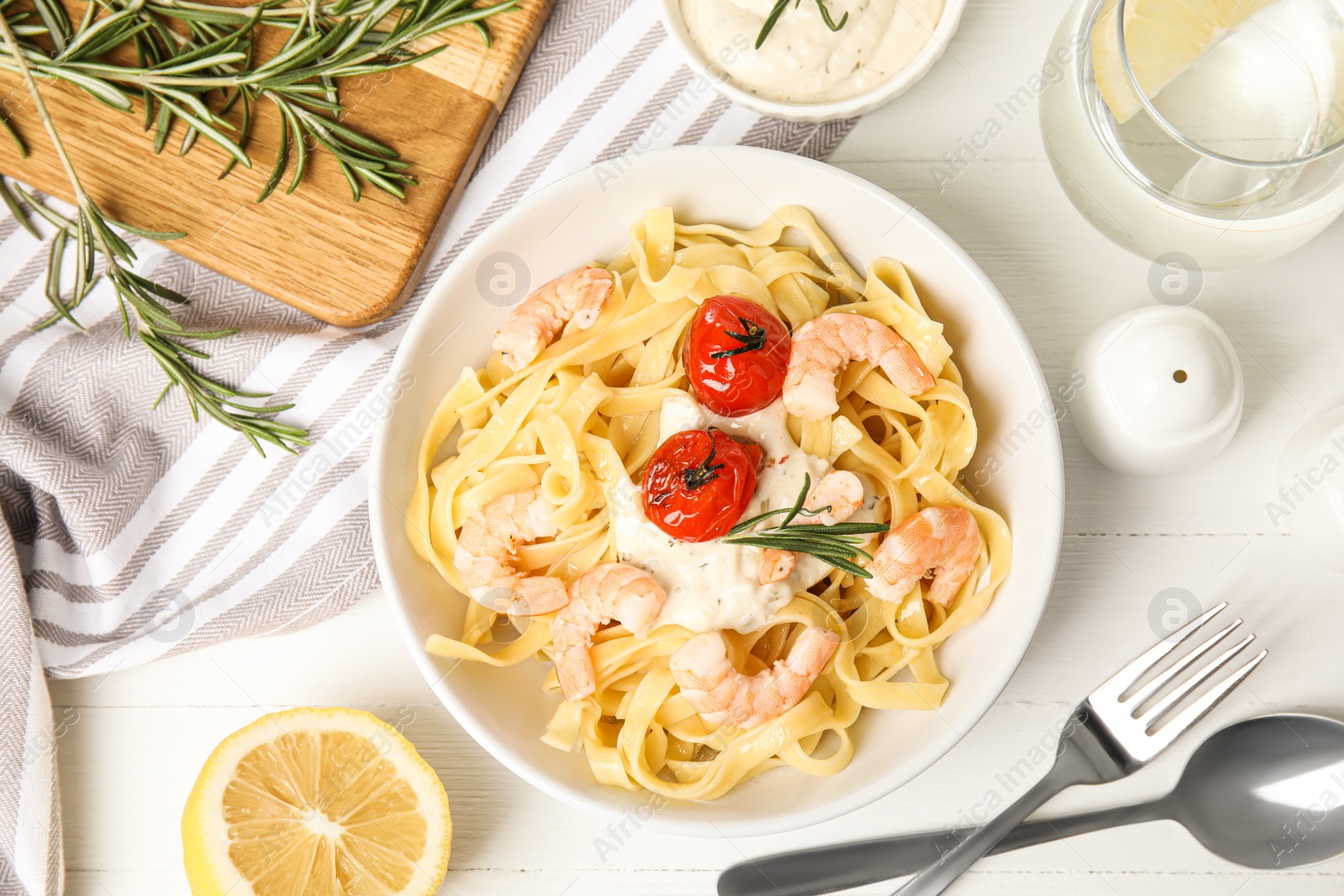 Photo of Delicious pasta with shrimps served on white wooden table, flat lay