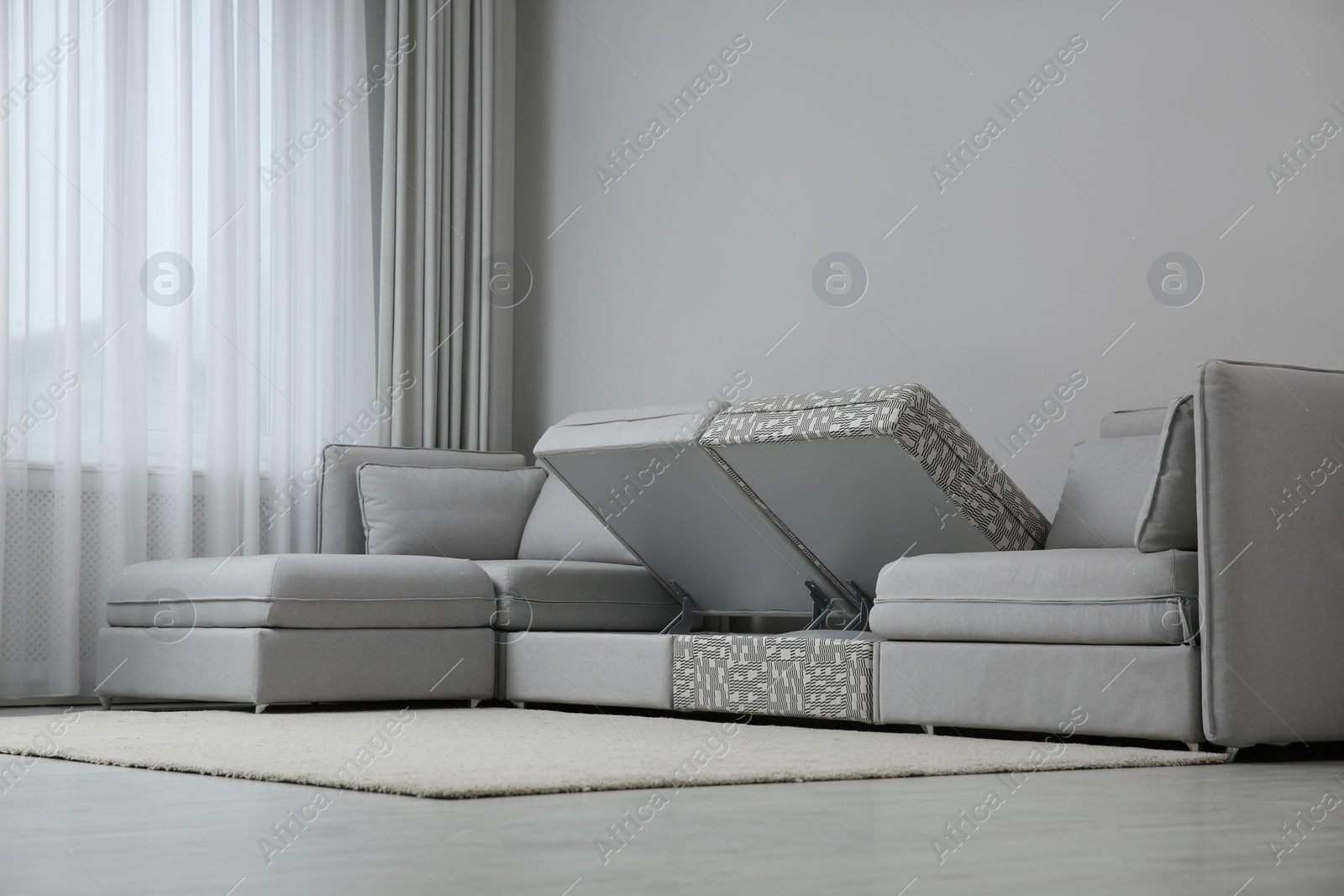 Photo of Modular sofa with storage near wall in living room. Interior design