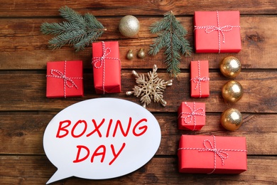 Photo of Speech bubble with phrase BOXING DAY and Christmas decorations on wooden background, flat lay