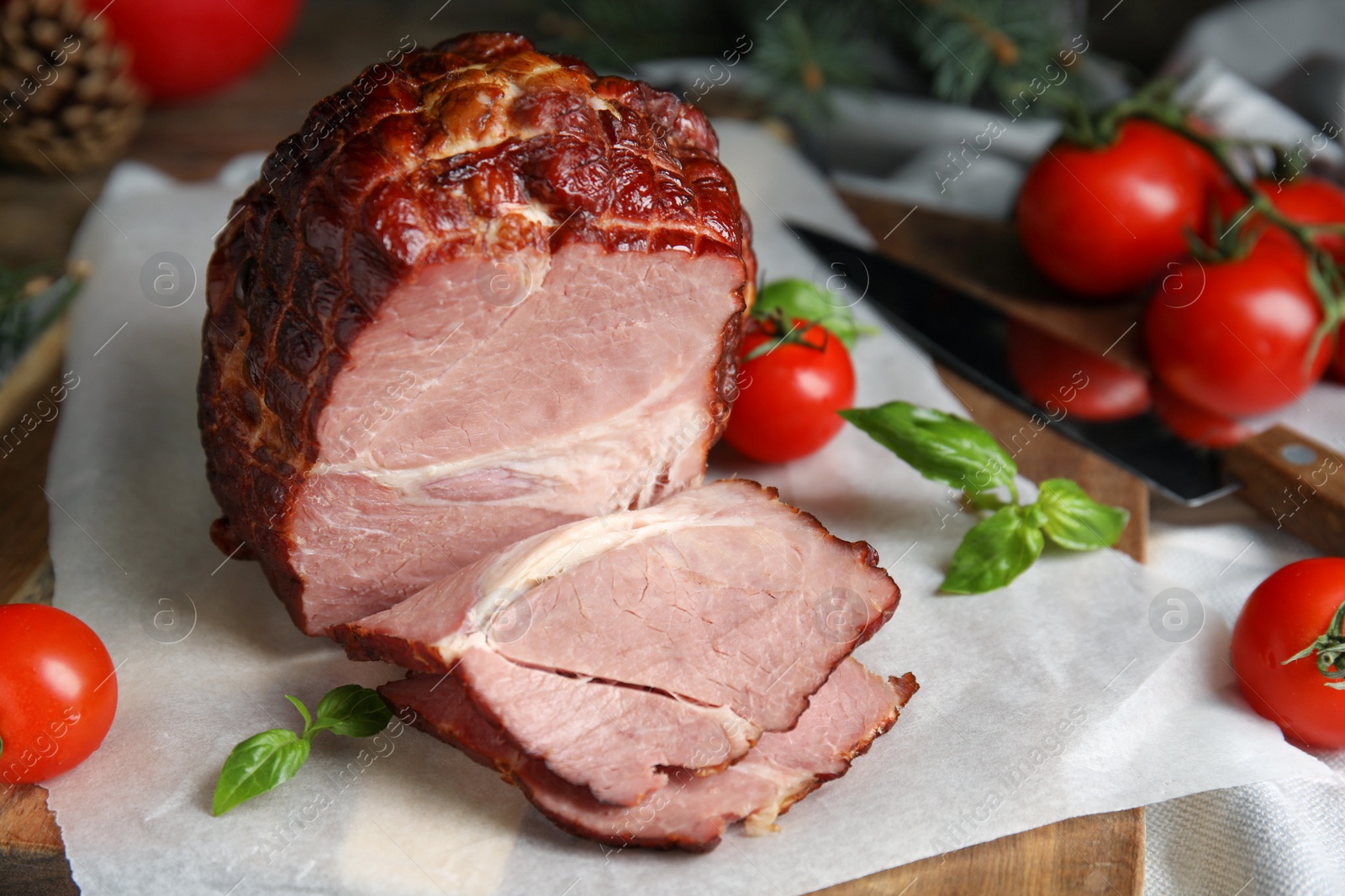 Photo of Delicious ham with tomatoes and basil on parchment, closeup. Christmas dinner