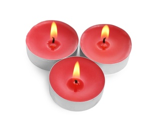 Photo of Colorful wax candles burning on white background