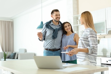 Photo of Female real estate agent working with couple, indoors