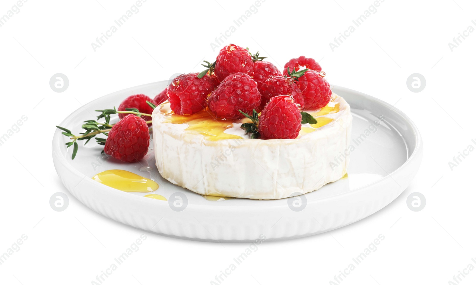 Photo of Brie cheese served with raspberries and honey isolated on white