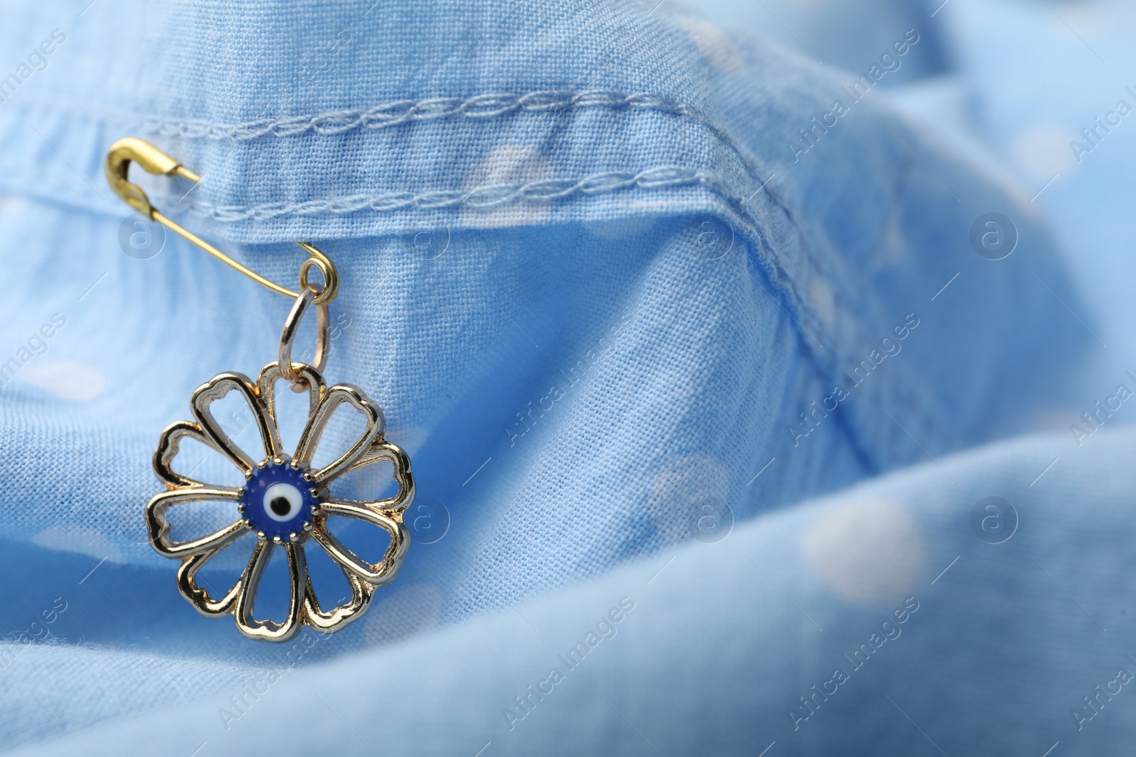 Photo of Evil eye safety pin on clothing, closeup