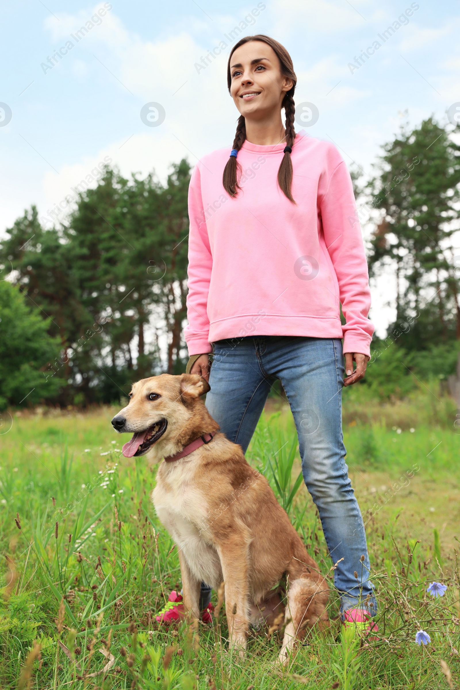 Photo of Female volunteer with homeless dog at animal shelter outdoors