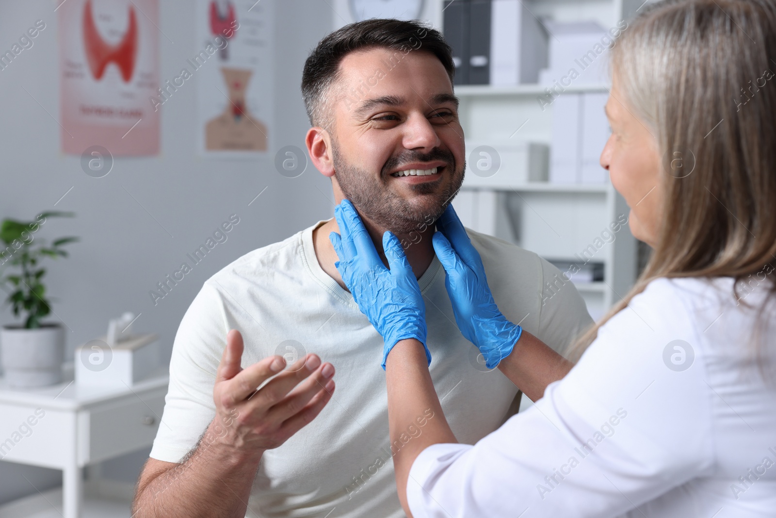 Photo of Endocrinologist examining thyroid gland of patient at hospital