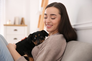 Woman with cute puppy indoors. Lovely pet