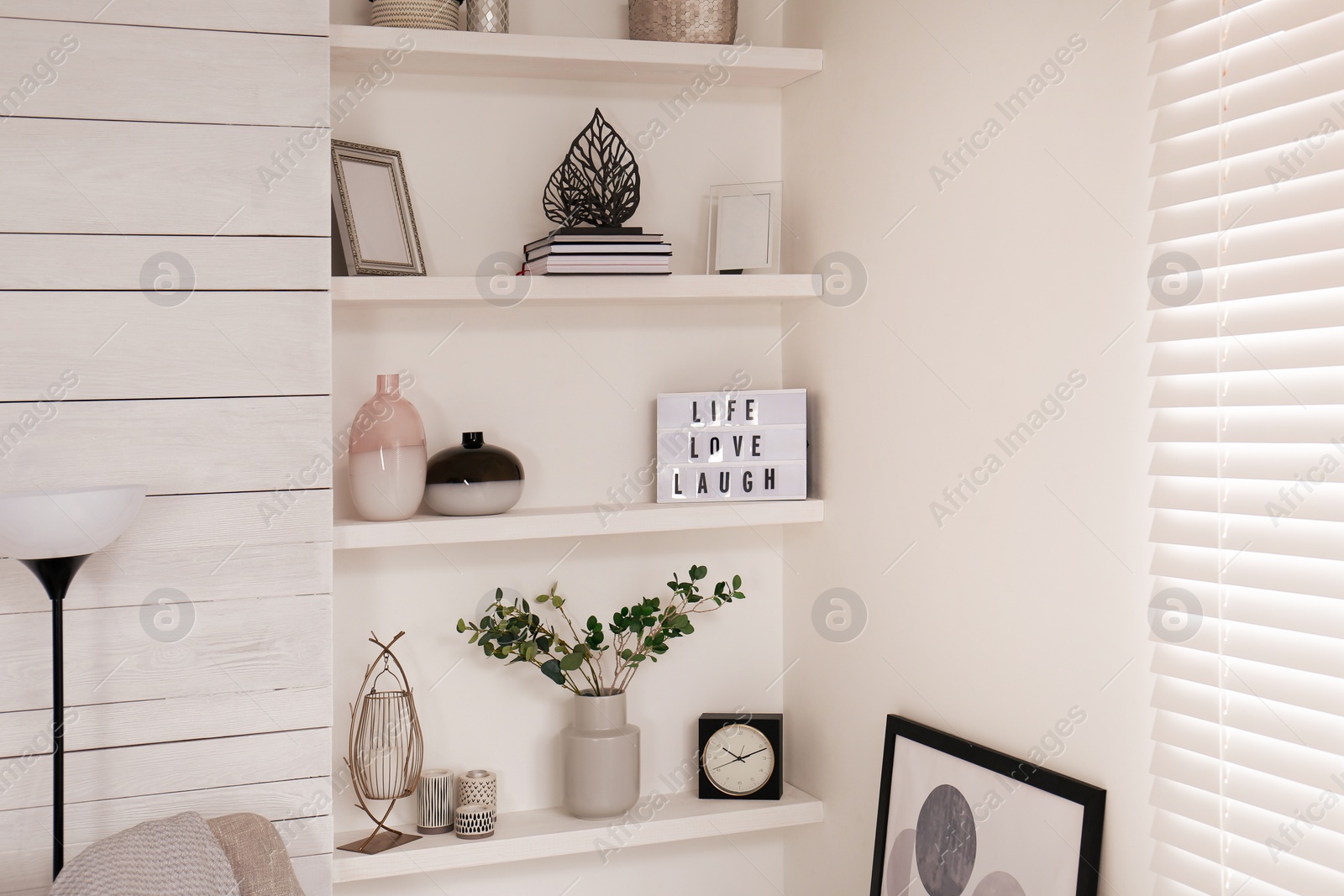 Photo of Wall shelves with beautiful decor elements indoors. Interior design