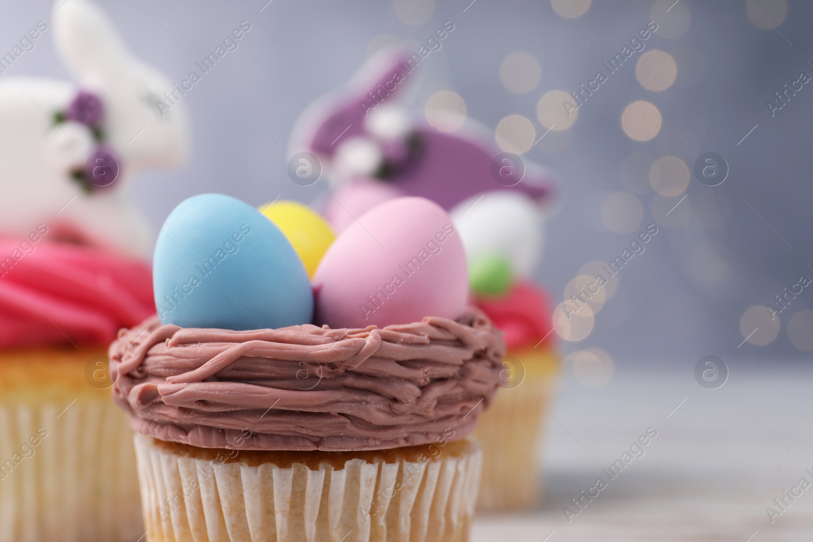 Photo of Tasty decorated Easter cupcake on table, closeup. Space for text