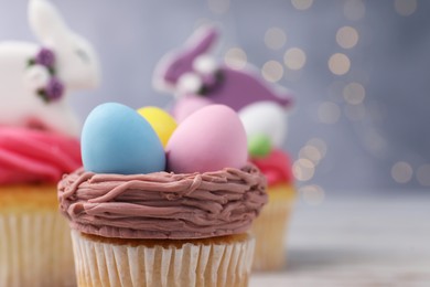 Photo of Tasty decorated Easter cupcake on table, closeup. Space for text