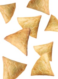 Crispy delicious samosas falling on white background