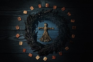 Image of Voodoo doll, wreath and runes on grey wooden background, flat lay