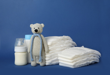Photo of Diapers and baby accessories on blue background