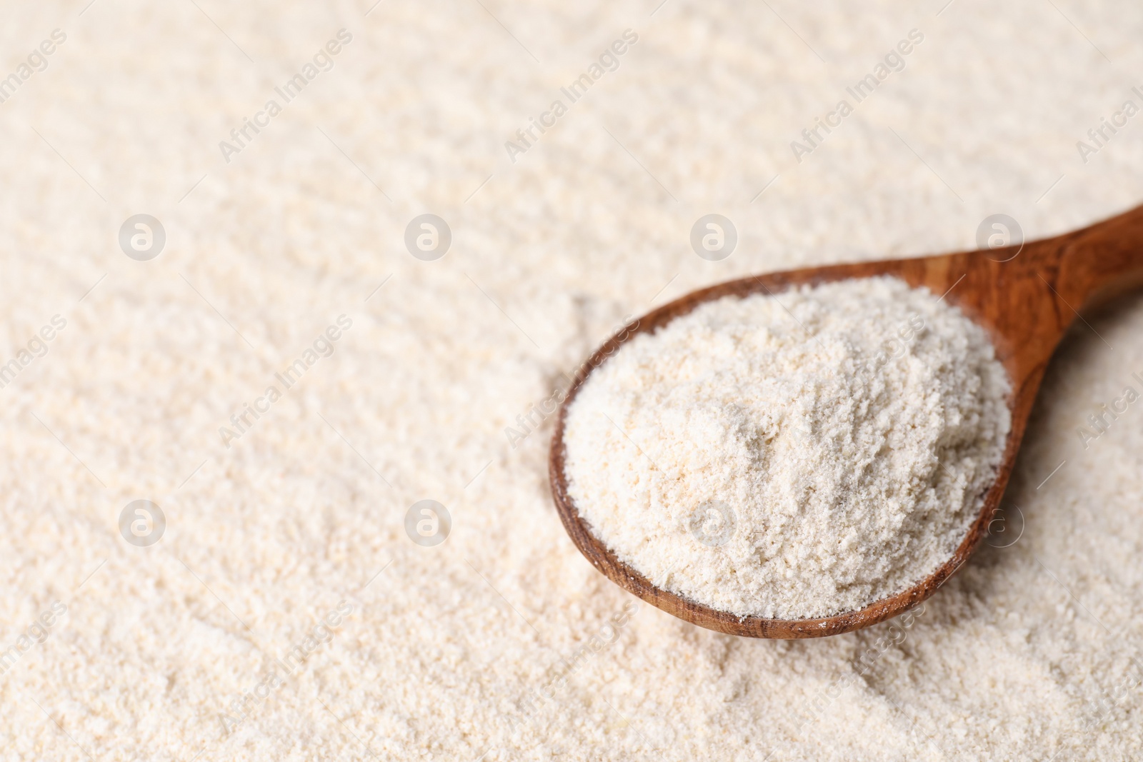 Photo of Quinoa flour and wooden spoon, space for text