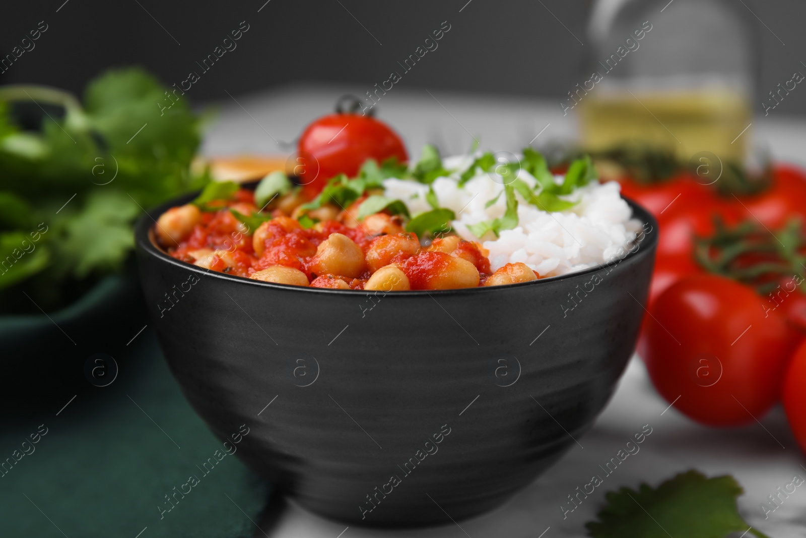 Photo of Delicious chickpea curry with rice in bowl on table, closeup