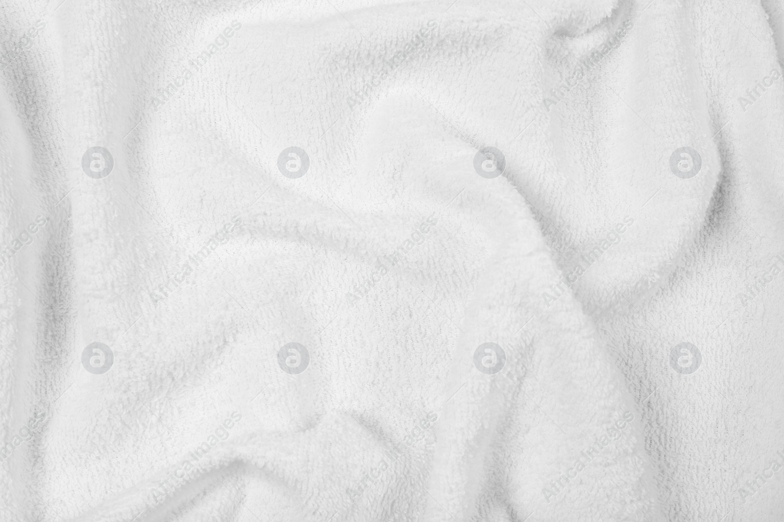 Photo of Crumpled white beach towel as background, top view