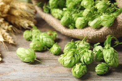 Photo of Fresh green hops on wooden table. Beer production