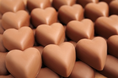 Tasty heart shaped chocolate candies as background, closeup. Valentine's day celebration