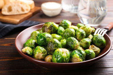 Photo of Delicious roasted Brussels sprouts on wooden table