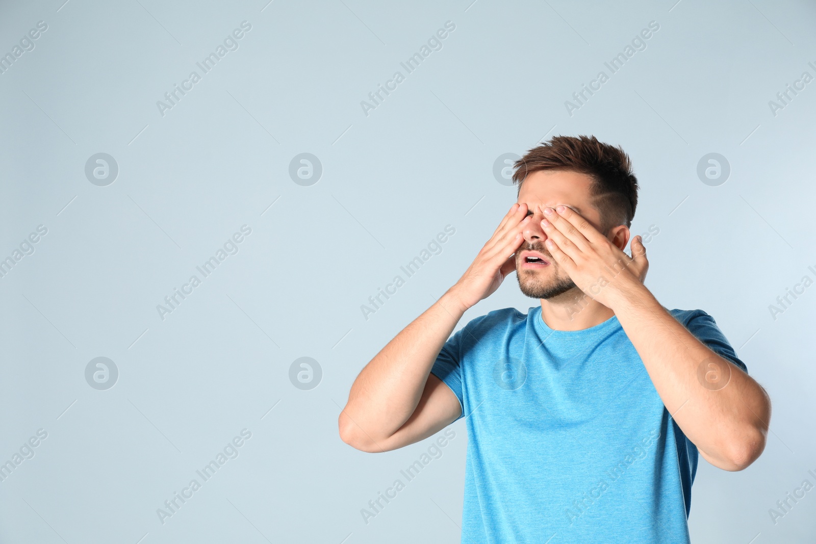 Photo of Young man being blinded on grey background, space for text