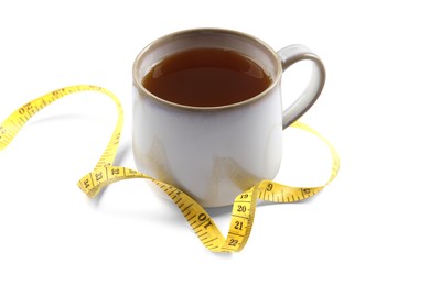 Ceramic cup of diet herbal tea and measuring tape on white background. Weight loss