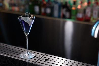 Photo of Fresh alcoholic cocktail in glass on bar counter. Space for text