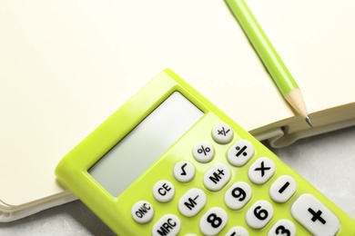 Photo of Calculator, notebook and pencil on light table, closeup. Tax accounting