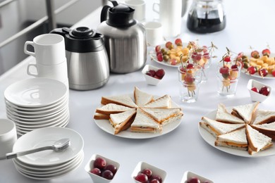 Table with different delicious snacks and dishware indoors. Coffee break