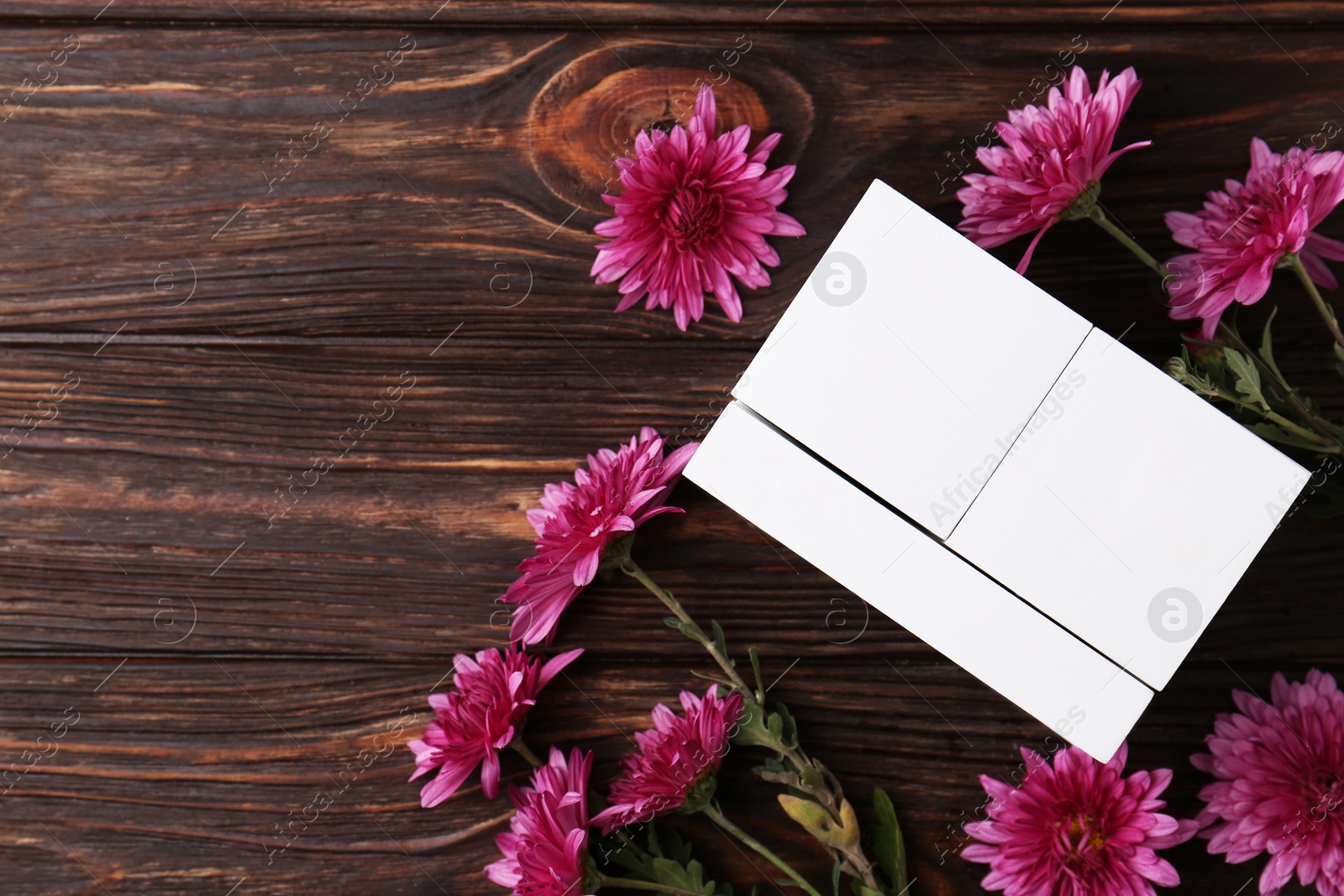 Photo of Thanksgiving day, holiday celebrated every fourth Thursday in November. Block calendar and beautiful chrysanthemums on wooden table, flat lay. Space for text