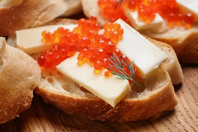 Photo of Delicious sandwich with red caviar, closeup