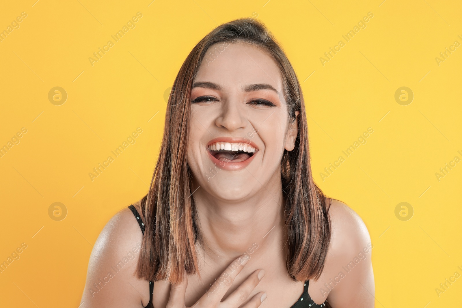 Photo of Happy beautiful young woman on yellow background