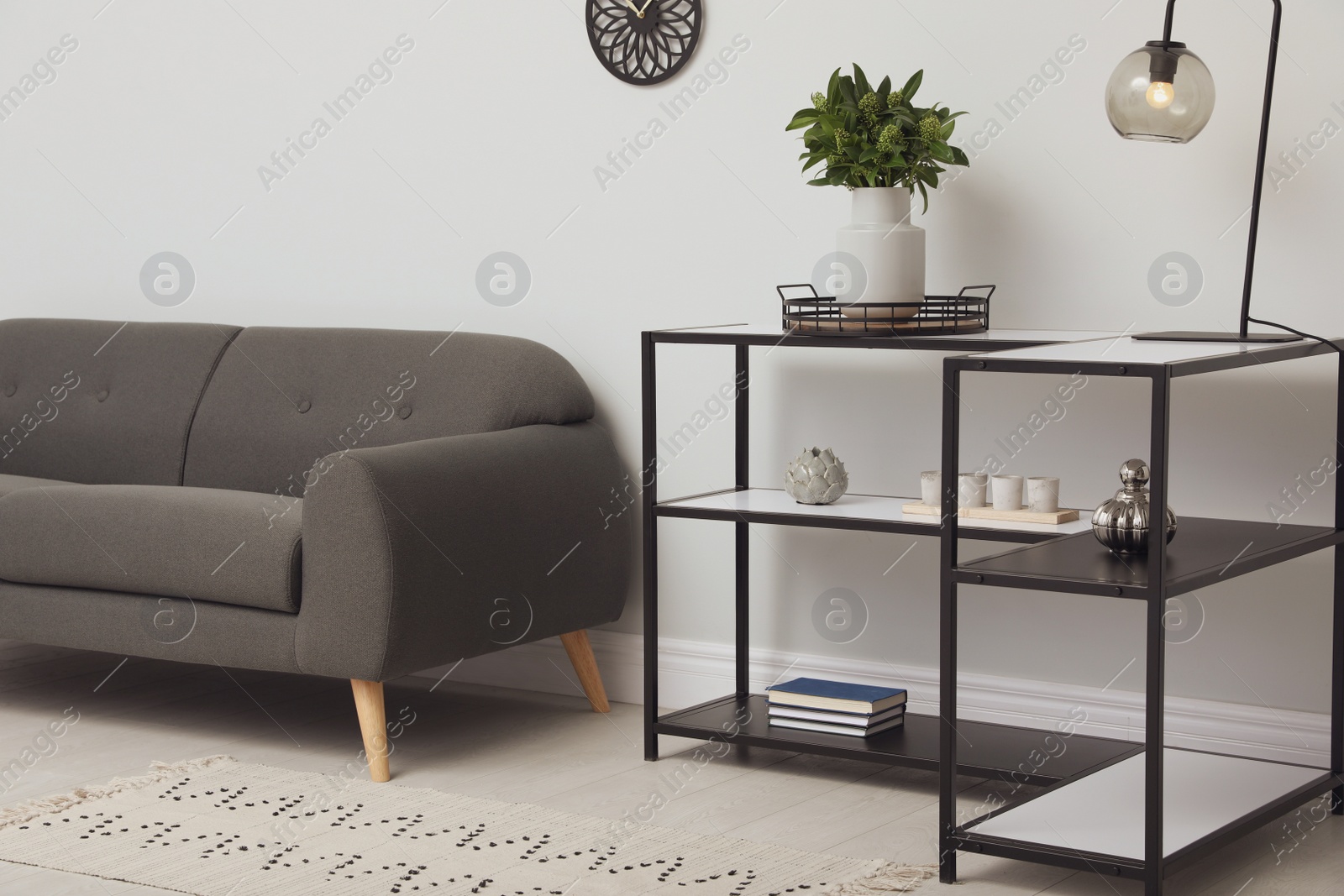 Photo of Console table with sofa near light wall in room. Interior design