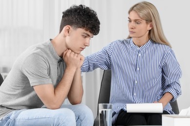 Psychologist working with teenage boy in office. Teenager problems