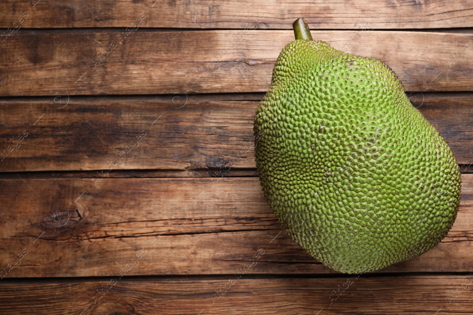 Photo of Fresh exotic jackfruit on wooden table, top view. Space for text