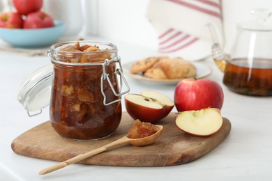 Delicious apple jam and fresh fruits on white table