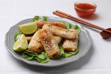 Photo of Tasty fried spring rolls served on white table, closeup