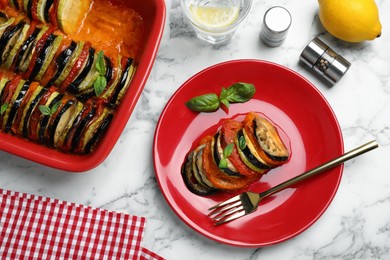 Photo of Delicious ratatouille with basil served on white marble table, flat lay