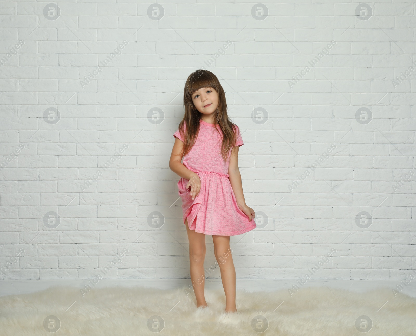 Photo of Portrait of cute little girl against brick wall