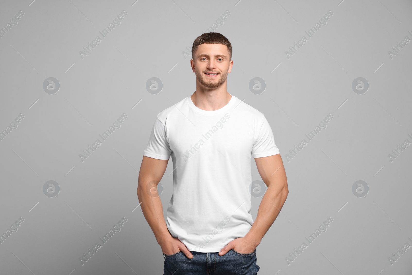 Photo of Man wearing white t-shirt on light grey background. Mockup for design