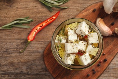 Photo of Flat lay composition with marinated feta on wooden table