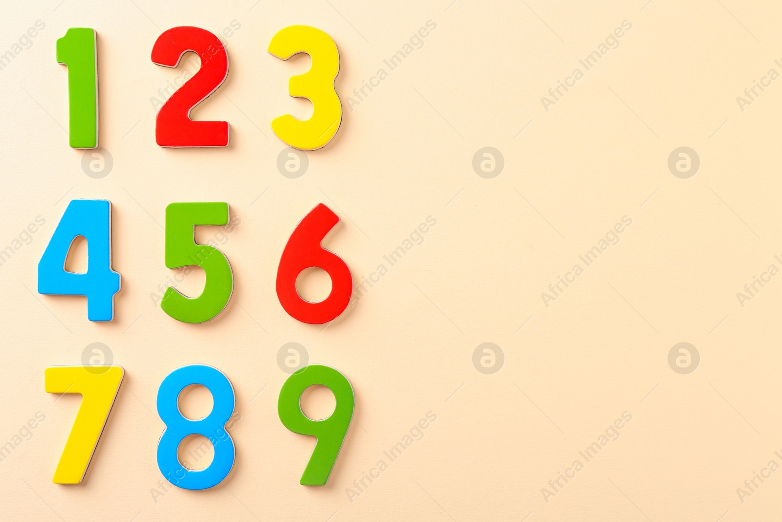 Photo of Colorful numbers on beige background, flat lay. Space for text